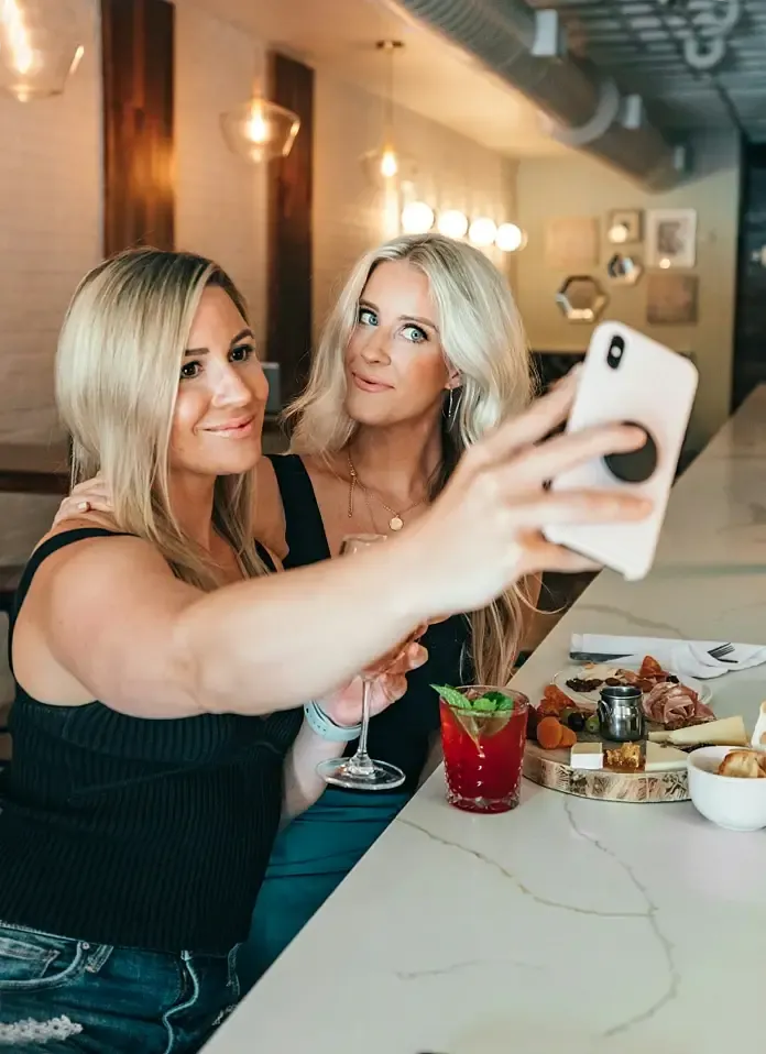 Two friends posing together for a selfie on a phone