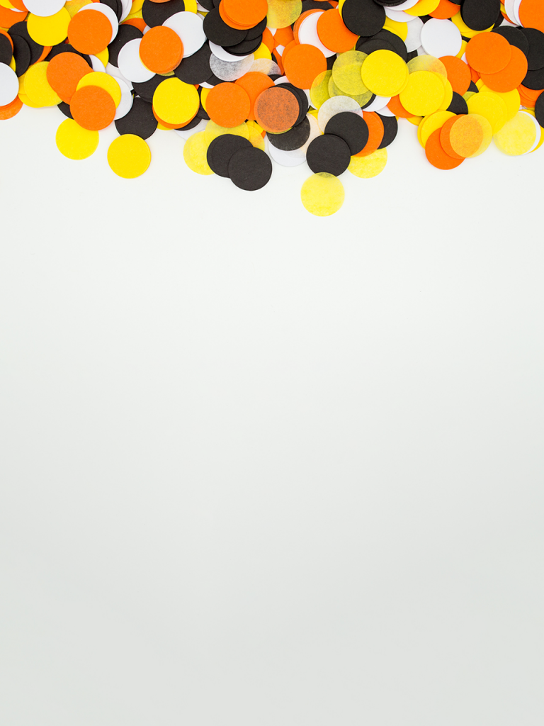 minimal photo booth background with orange, black, and white halloween confetti