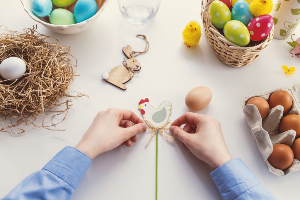 boy tying string on Easter decorations