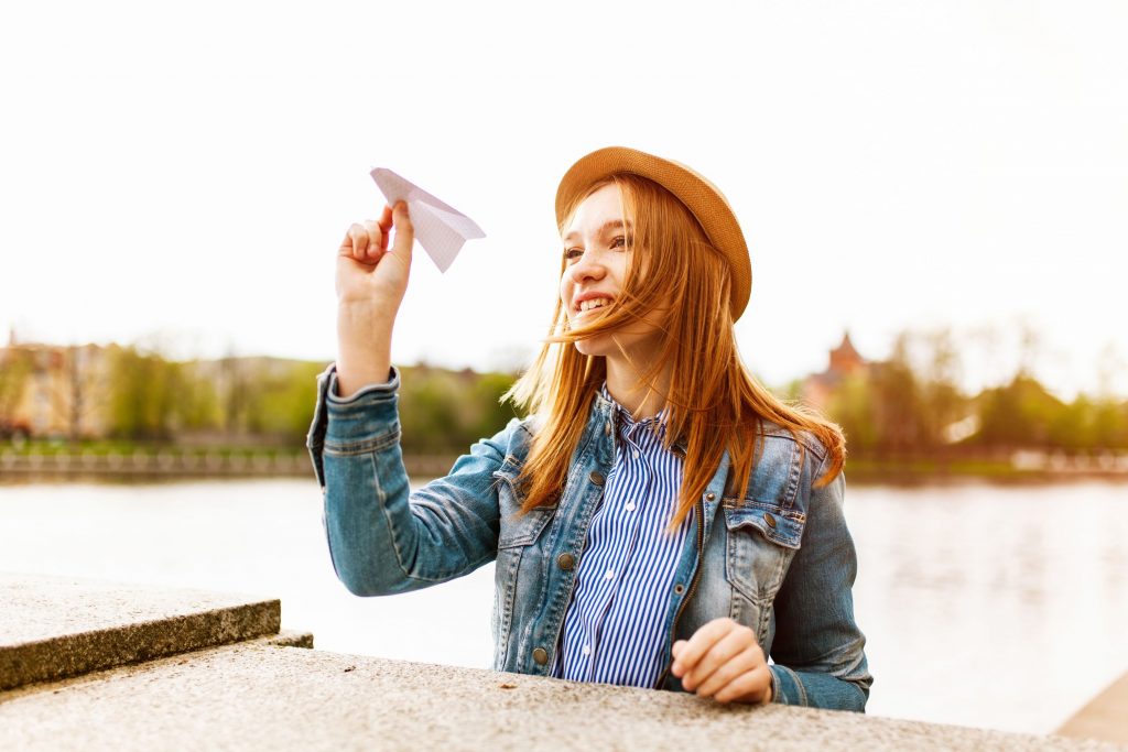 teenage throwing a paper airplane at home