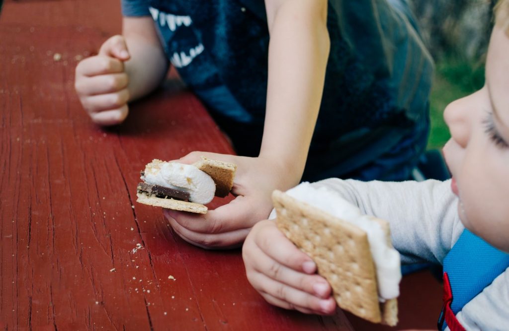 kids eating smores at backyard picnic table