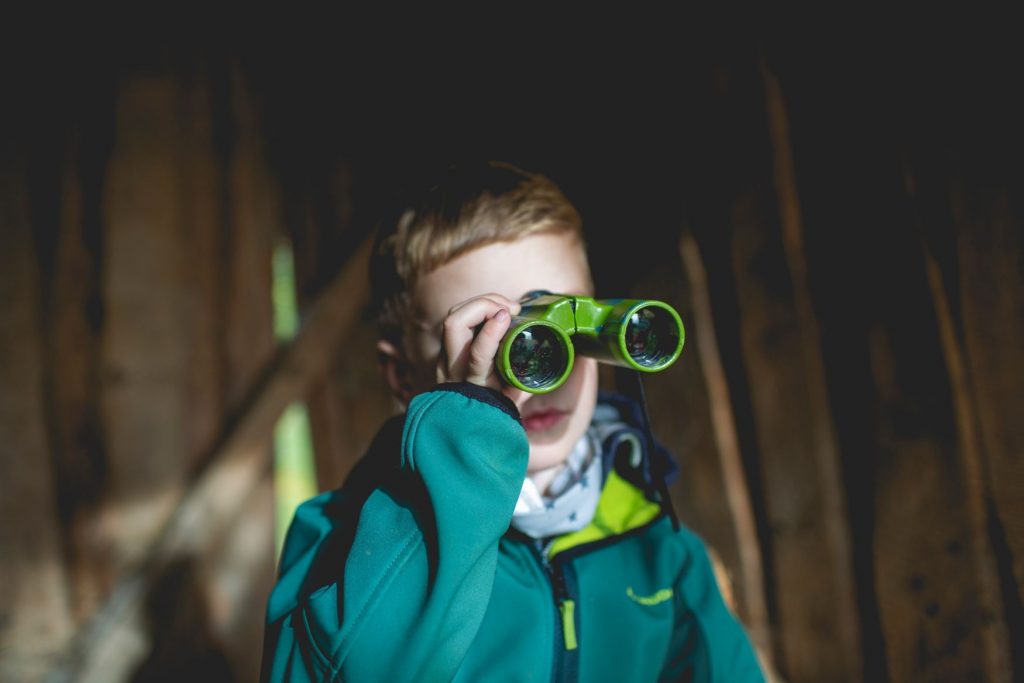 young boy on birdwatch in backyard