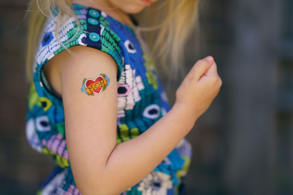 little girl wearing temporary tattoo at home