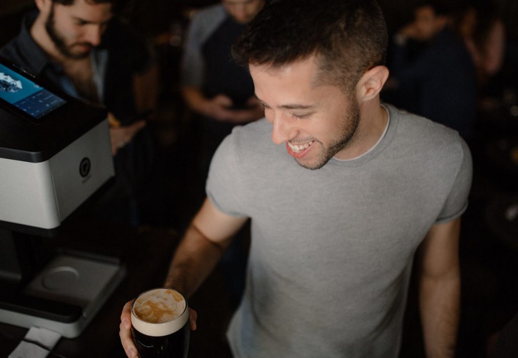 Man with beer that has photo printed in the foam