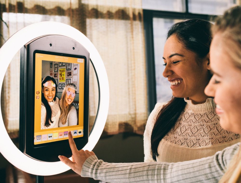 Woman and man smile toward iPad with HALO