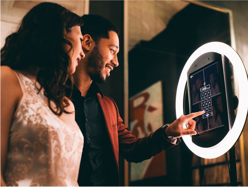 Woman touching Simple Booth app on iPad surrounded by HALO